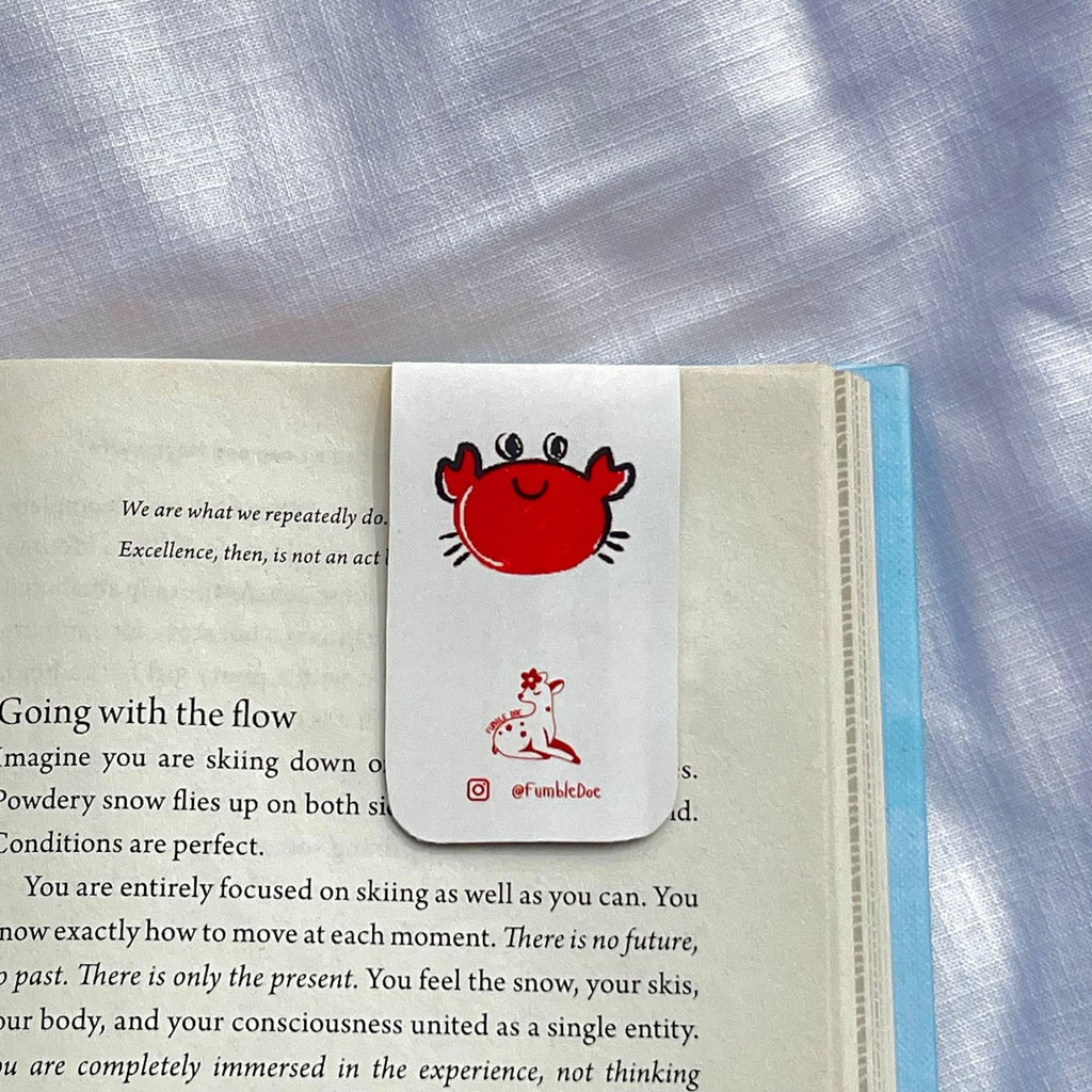 Book with a red crab bookmark on a textured fabric background