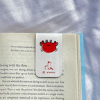 Book with a red crab bookmark on a textured fabric background