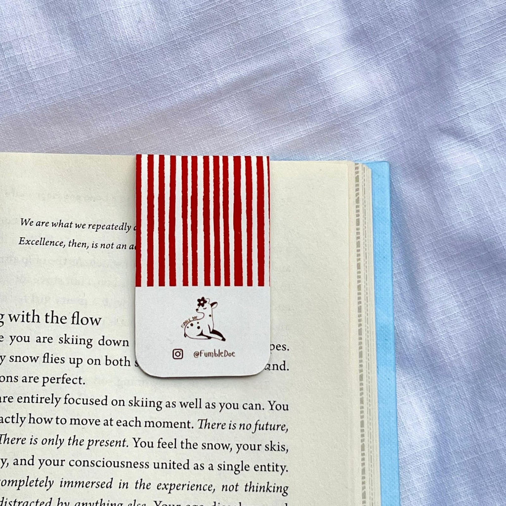 Red and white striped bookmark with fumbledoe logo on an open book
