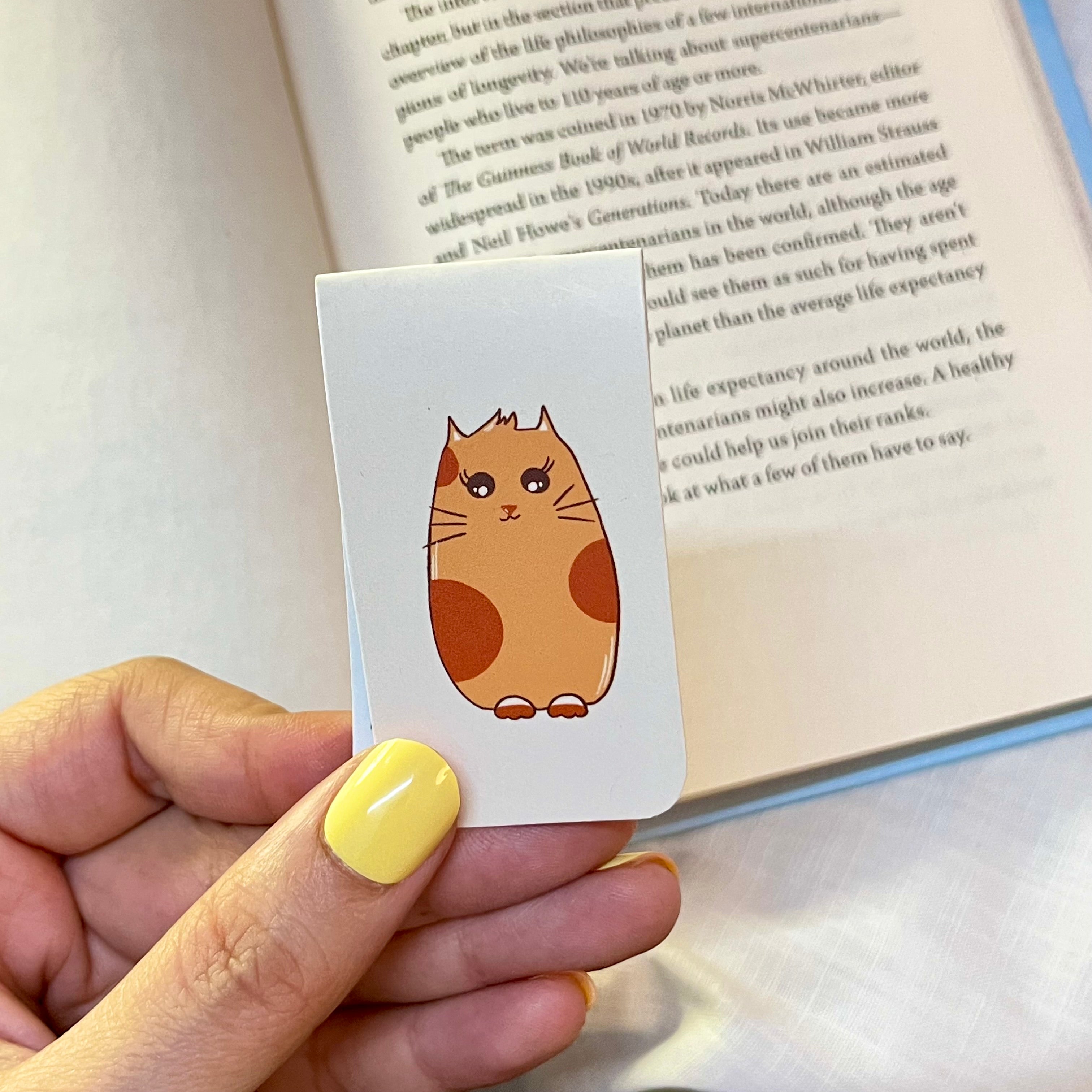bookmark with a cat illustration over an open book