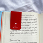 Open book with a red bookmark featuring a doe illustration