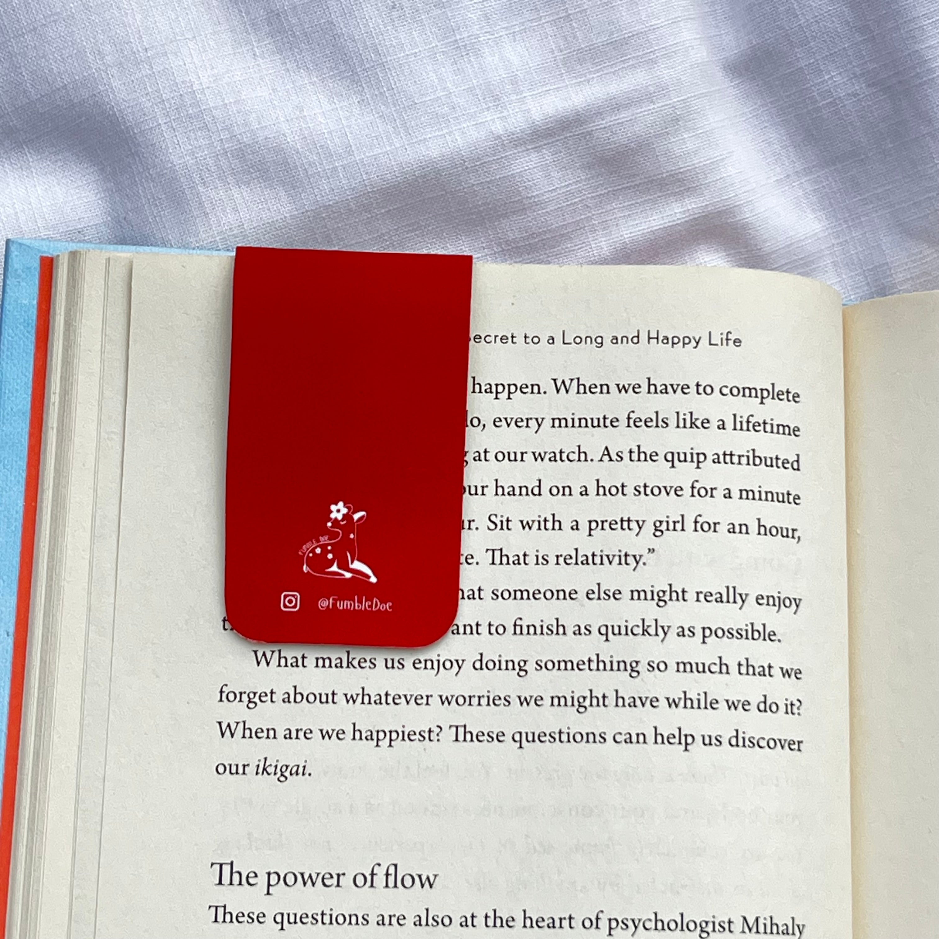 Open book with a red bookmark featuring a doe illustration