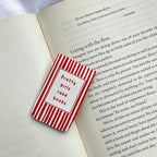 Red and white striped bookmark with 'Pretty girls read books' text on an open book.