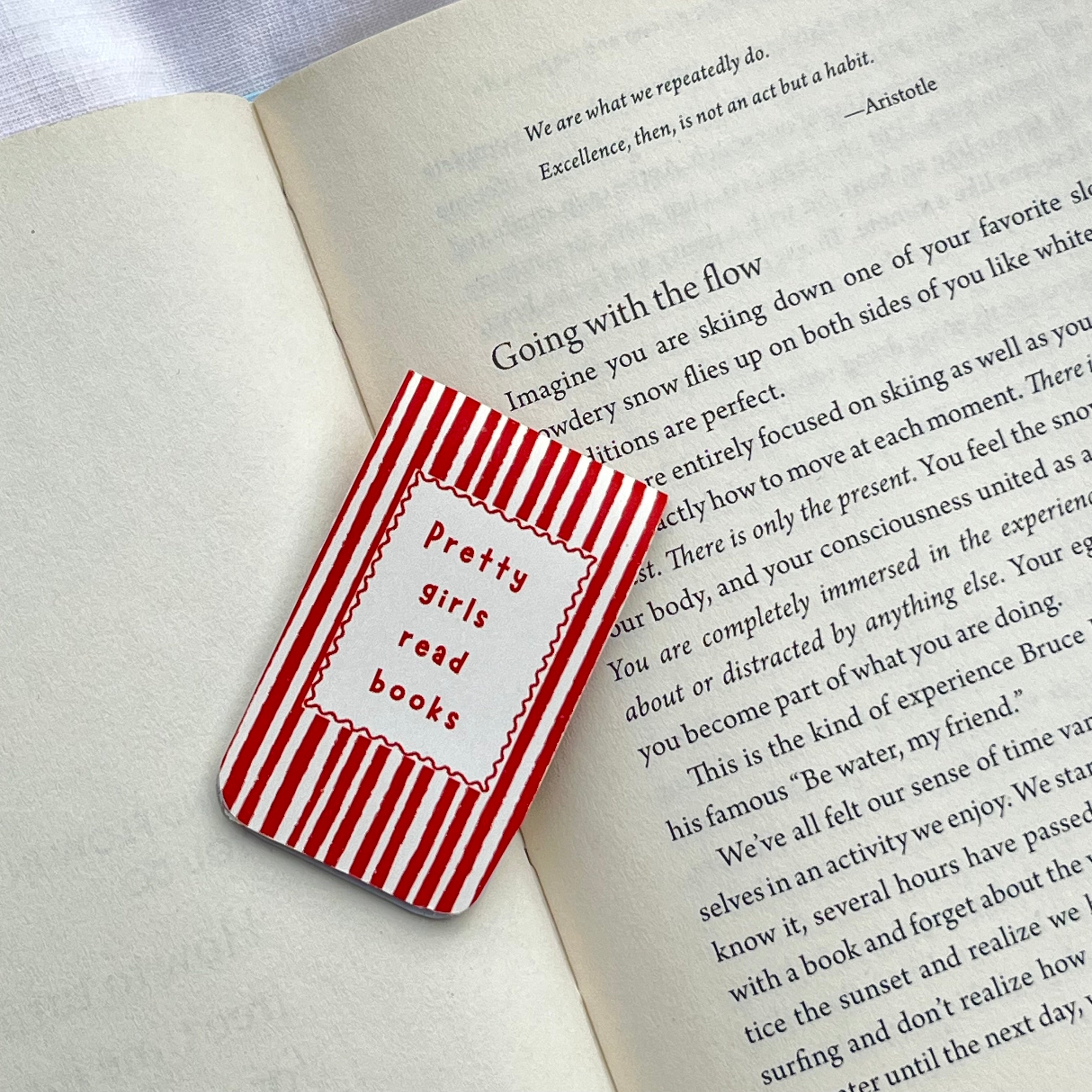Red and white striped bookmark with 'Pretty girls read books' text on an open book.