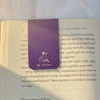 Open book with a purple bookmark on a textured surface