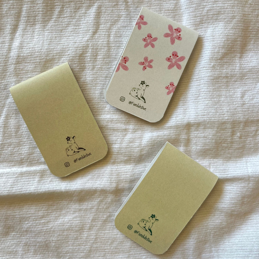 Three small notebooks with animal illustrations on a textured surface