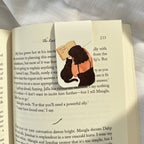 Book with a bookmark featuring an illustration of a person hugging a book, placed on a white surface.