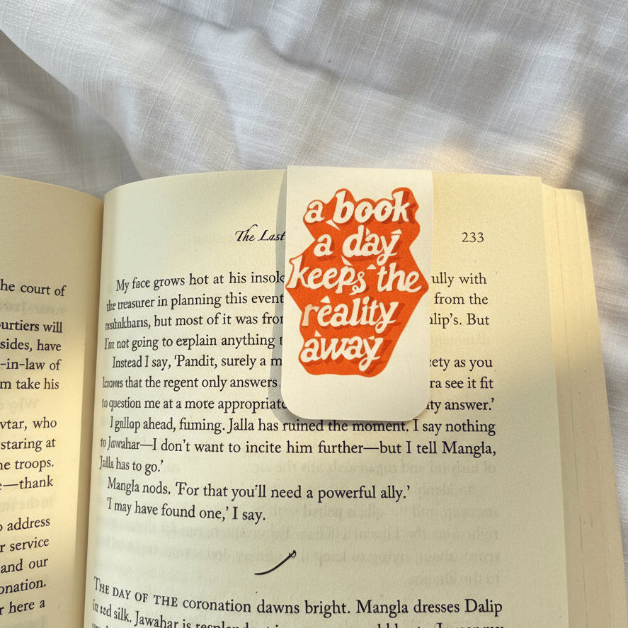 Open book with a bookmark inside, featuring text and a decorative design.