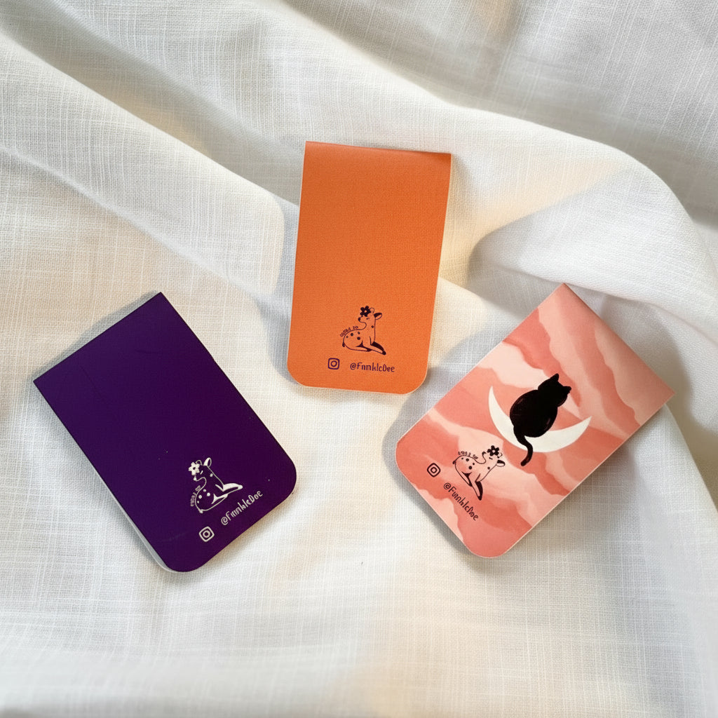 Three small rectangular pouches with unique designs on a white fabric background