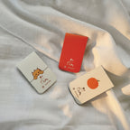 Three small cards with illustrations on a white fabric background